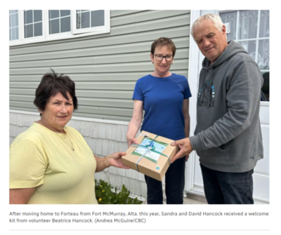 After moving home to Forteau from Fort McMurray, Alta. this year, Sandra and David Hancock received a welcome kit from volunteer Beatrice Hancock. (Andrea McGuire/CBC)